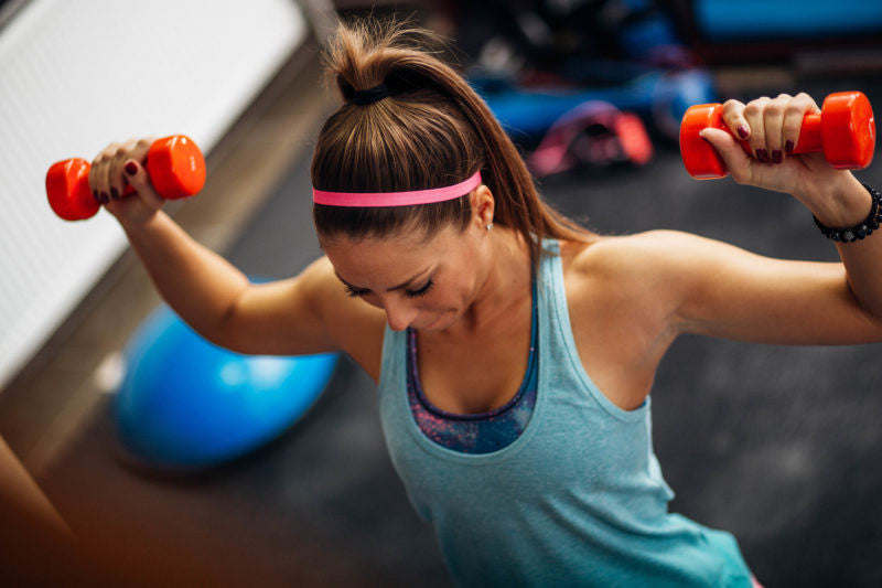girl lifting dumbbells at gym