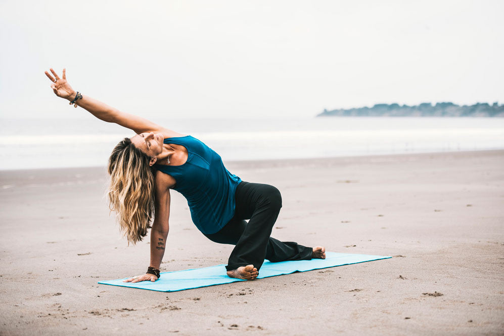 Woman doing yoga on the beach 