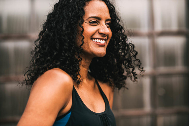 Woman with dark curly hair smiling 