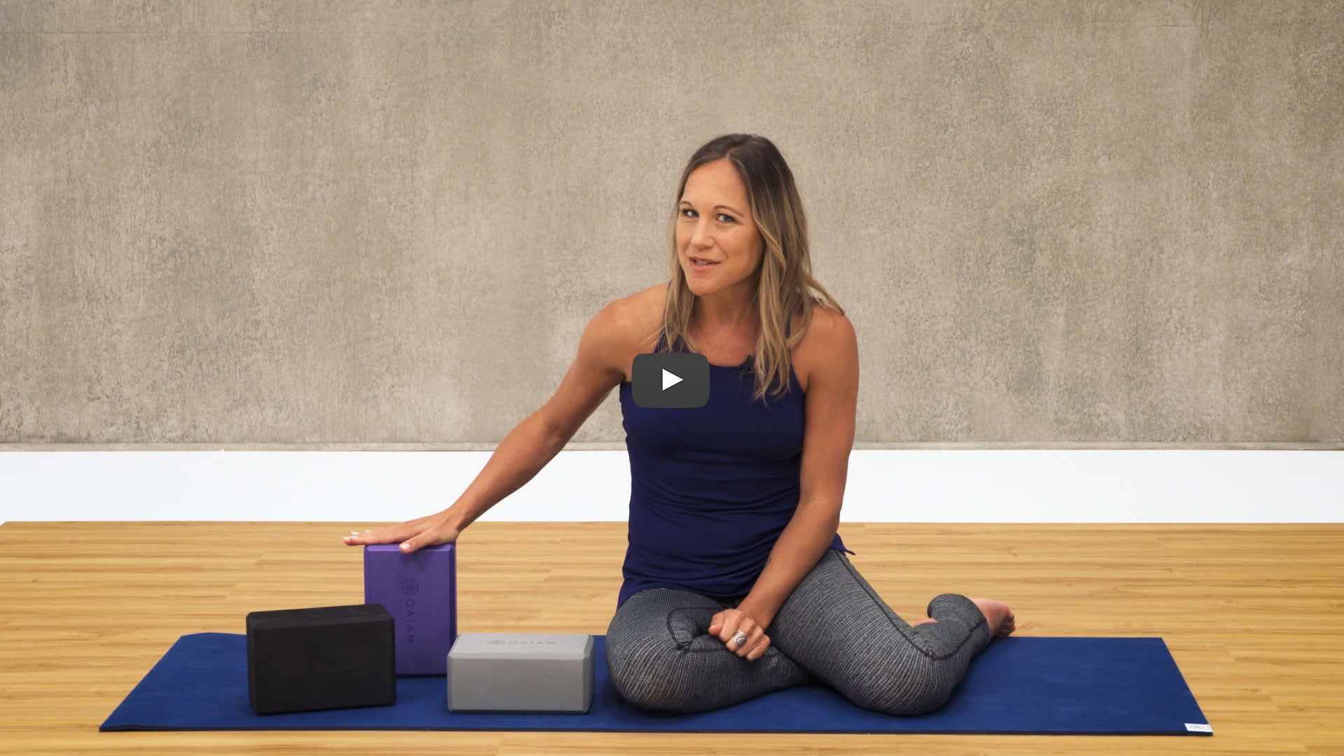 woman puts hand on yoga block 