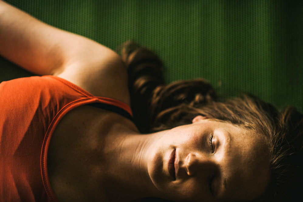 Woman on a yoga mat with eyes closed
