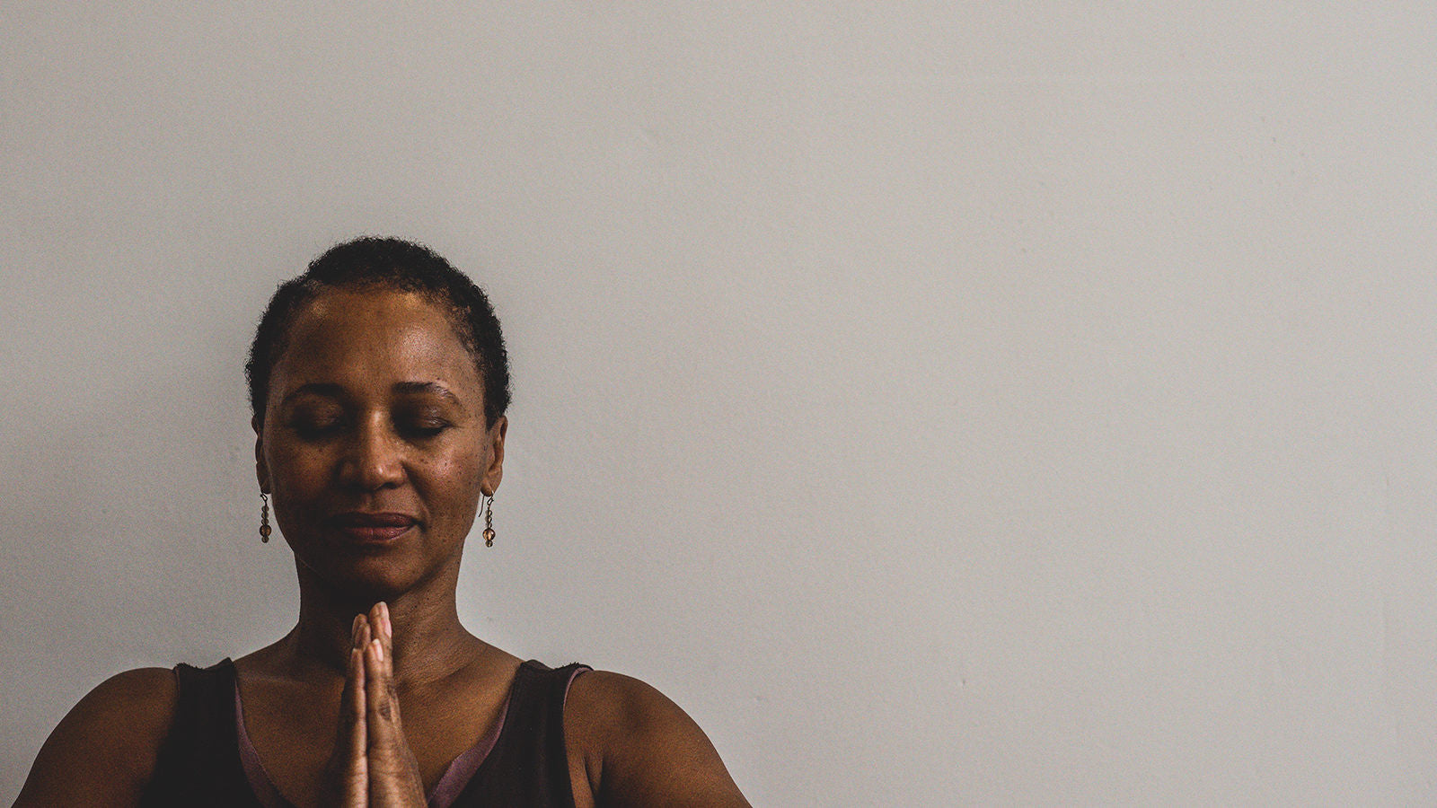 Yoga teacher has hands in prayer 
